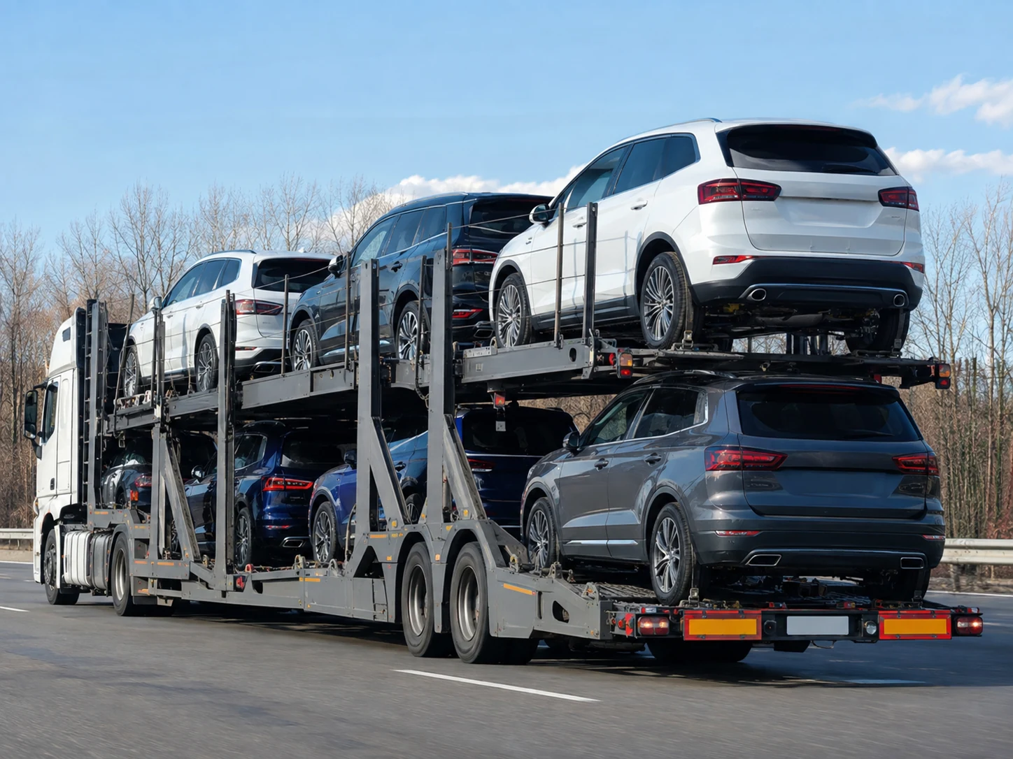 Camion porte-voitures transportant plusieurs voitures sur autoroute